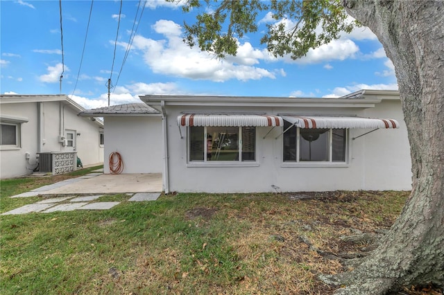 back of property with a lawn, a patio, and central air condition unit