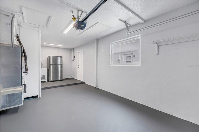 garage featuring a garage door opener and stainless steel fridge