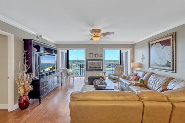 living room featuring light wood-type flooring, ceiling fan, and crown molding