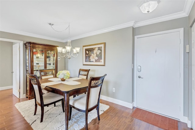 dining space with crown molding, a chandelier, and hardwood / wood-style flooring