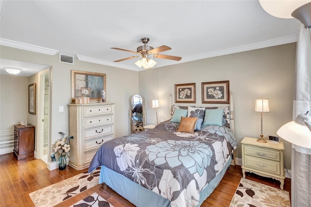 bedroom with ceiling fan, crown molding, and light hardwood / wood-style floors