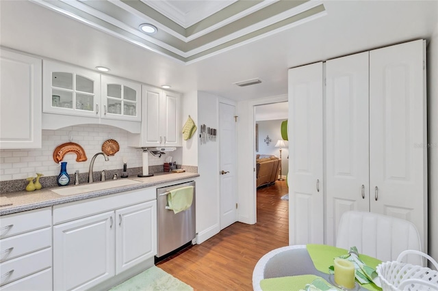 kitchen featuring stainless steel dishwasher, sink, and white cabinets