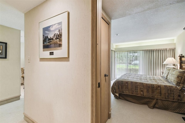 bedroom with a textured ceiling and light carpet