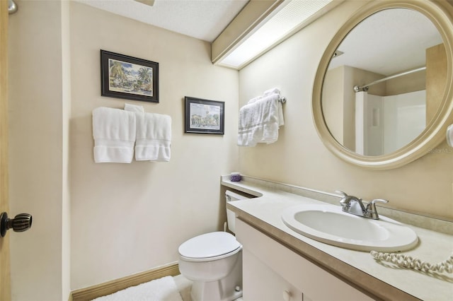 bathroom featuring a shower, vanity, and toilet