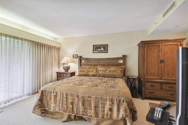 bedroom featuring a textured ceiling and light colored carpet