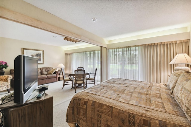 bedroom featuring a textured ceiling, beamed ceiling, and light colored carpet