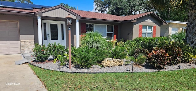 single story home featuring a garage and a front lawn