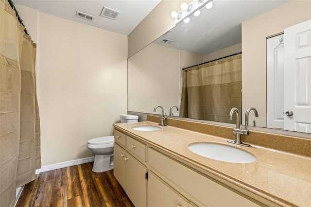 bathroom featuring toilet, vanity, and wood-type flooring