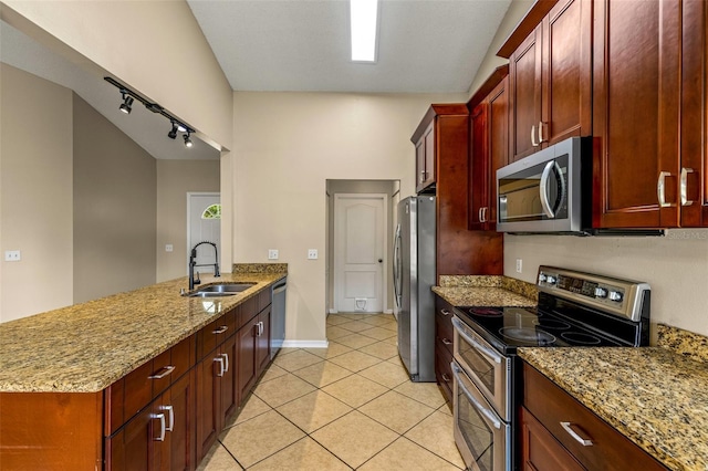 kitchen with stainless steel appliances, sink, light tile patterned floors, kitchen peninsula, and light stone countertops