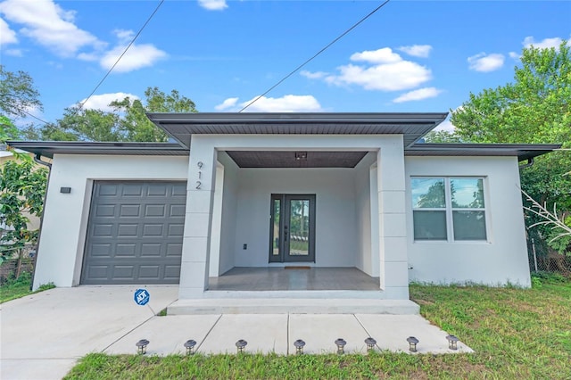 view of front facade featuring a front lawn, a garage, and covered porch