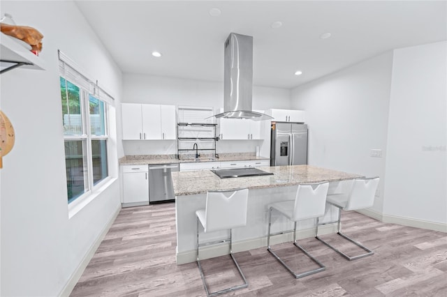 kitchen with appliances with stainless steel finishes, island range hood, white cabinetry, and a center island