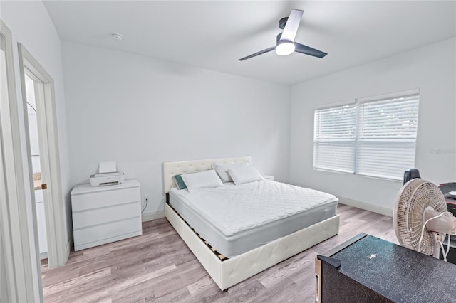 bedroom with light hardwood / wood-style floors and ceiling fan