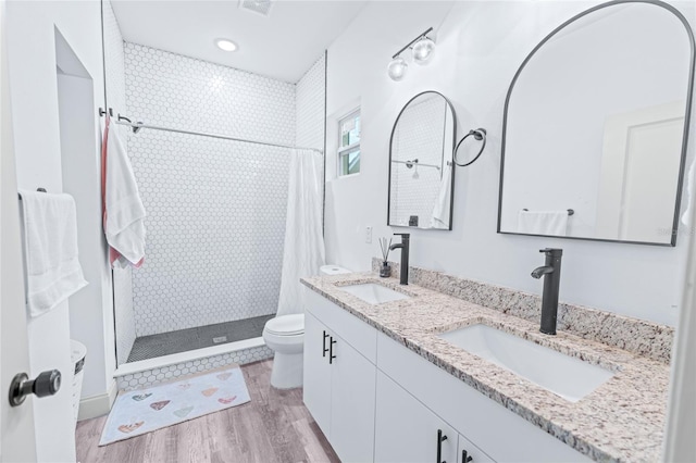 bathroom with vanity, hardwood / wood-style floors, toilet, and curtained shower