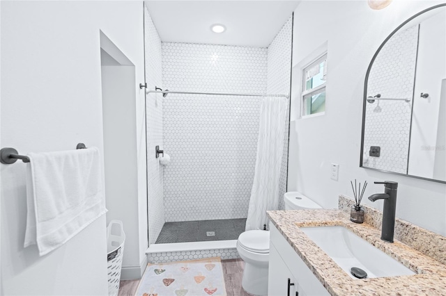 bathroom with hardwood / wood-style flooring, vanity, toilet, and a shower with curtain