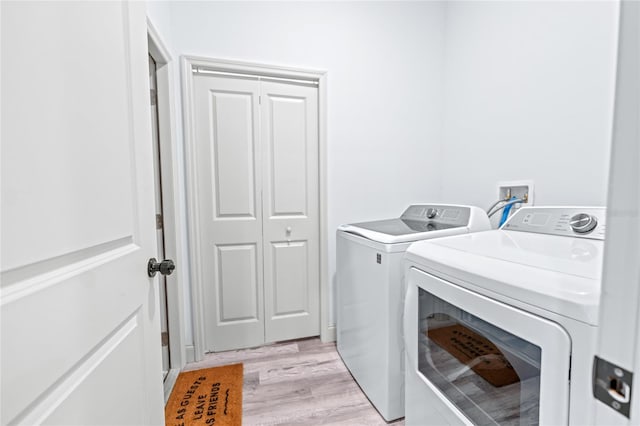 laundry room featuring light hardwood / wood-style flooring and washer and dryer