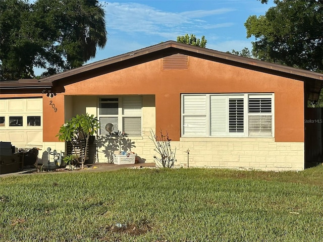 view of side of property with a lawn and a garage