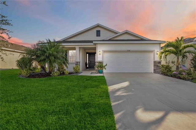 view of front of home with a garage and a lawn