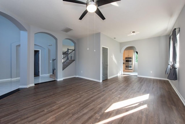 unfurnished living room featuring dark hardwood / wood-style floors and ceiling fan