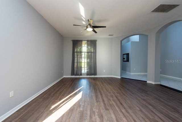 unfurnished room with ceiling fan and dark wood-type flooring