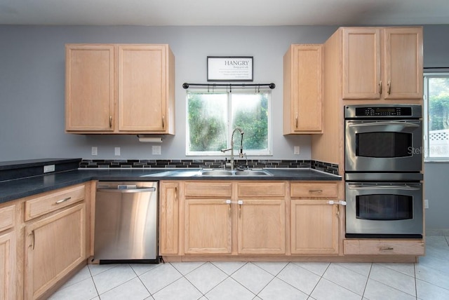 kitchen with light brown cabinetry, light tile patterned flooring, appliances with stainless steel finishes, and sink