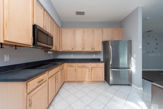 kitchen with light brown cabinets, appliances with stainless steel finishes, and light tile patterned floors