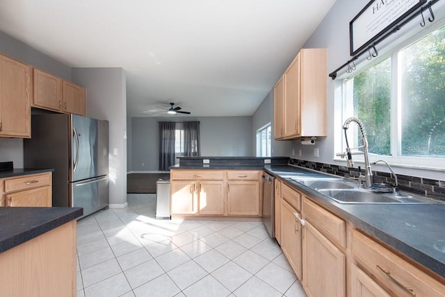 kitchen featuring appliances with stainless steel finishes, light tile patterned floors, sink, and ceiling fan