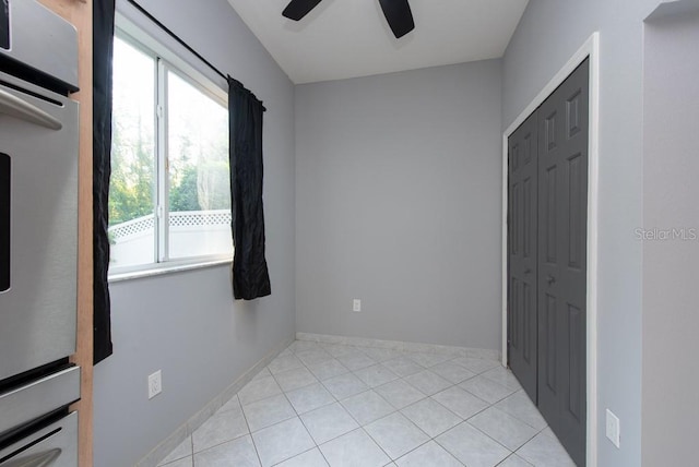 bedroom with ceiling fan, a closet, and light tile patterned floors