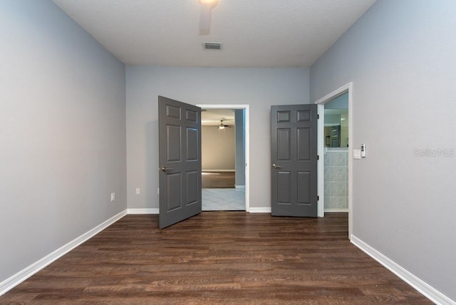 unfurnished bedroom with ceiling fan and dark hardwood / wood-style floors