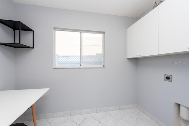 washroom featuring cabinets, hookup for an electric dryer, and light tile patterned floors