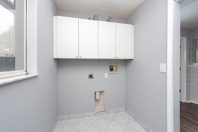 laundry area with cabinets, electric dryer hookup, hookup for a washing machine, and light tile patterned flooring