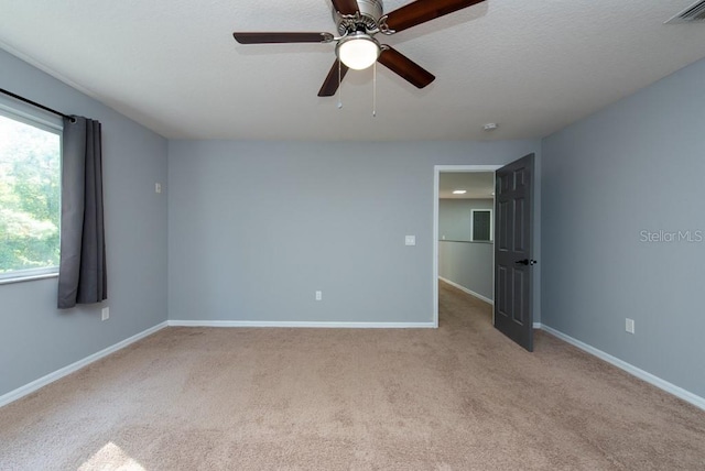 spare room with ceiling fan and light carpet