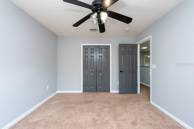 unfurnished bedroom with a closet, ceiling fan, and light colored carpet