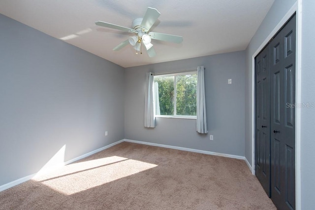 carpeted spare room featuring ceiling fan