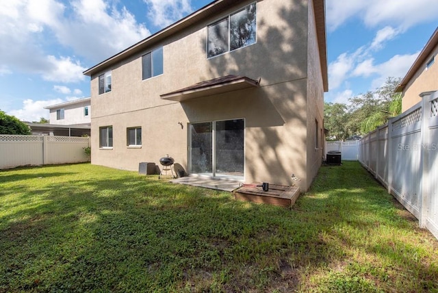 back of property with cooling unit and a yard