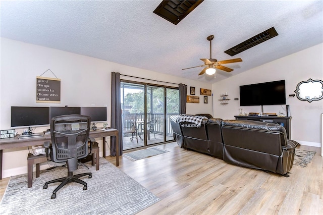 office space featuring light hardwood / wood-style flooring, lofted ceiling, ceiling fan, and a textured ceiling