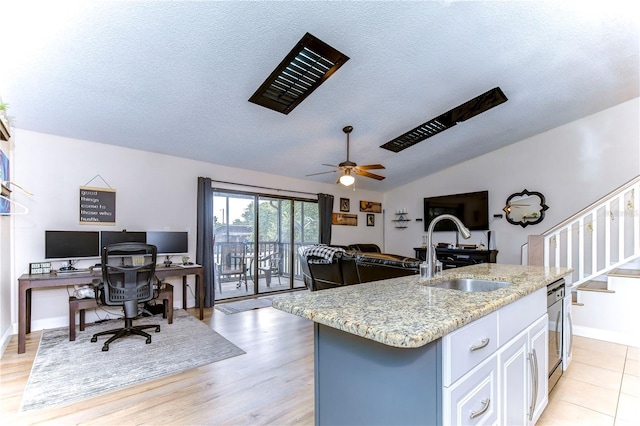 kitchen featuring an island with sink, light hardwood / wood-style floors, sink, and white cabinetry