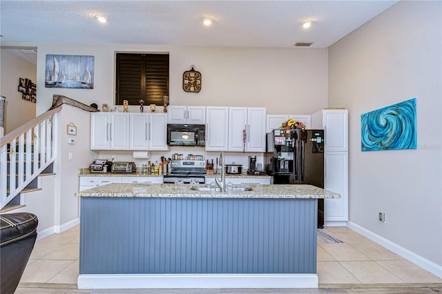 kitchen featuring sink, a textured ceiling, a center island with sink, white cabinetry, and black appliances