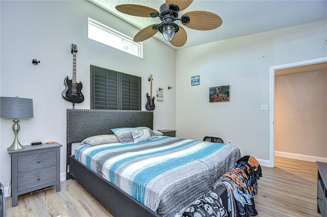 bedroom featuring light wood-type flooring, a textured ceiling, and ceiling fan