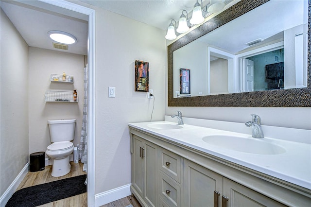 bathroom featuring wood-type flooring, vanity, and toilet