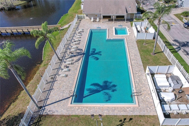 view of swimming pool featuring a water view and a patio area