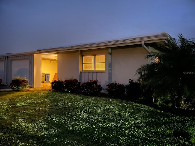 property exterior at dusk featuring a yard