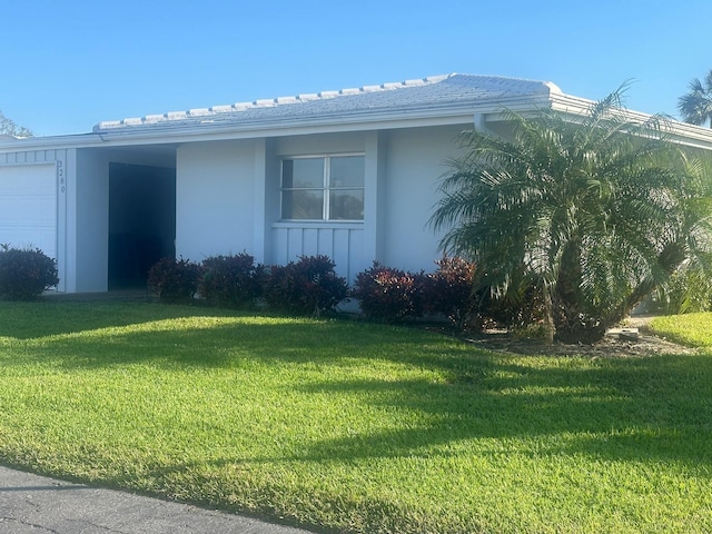 view of front of home featuring a garage and a front lawn