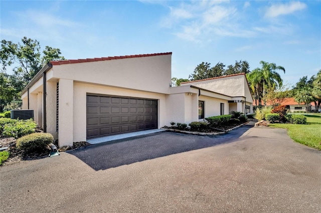 view of front of property featuring cooling unit and a garage