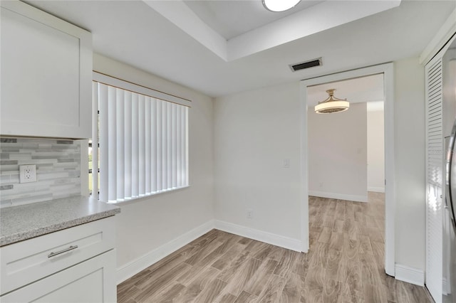 unfurnished dining area featuring light wood-type flooring