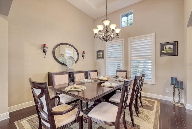 dining area featuring a chandelier, dark wood-type flooring, and high vaulted ceiling