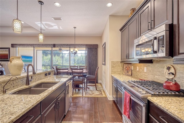 kitchen with hanging light fixtures, appliances with stainless steel finishes, dark hardwood / wood-style floors, and sink