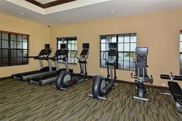 exercise room with a healthy amount of sunlight and dark colored carpet