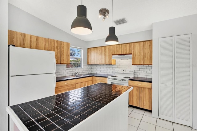 kitchen featuring sink, white appliances, hanging light fixtures, and vaulted ceiling