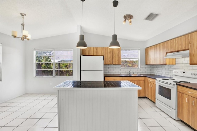 kitchen with backsplash, white appliances, vaulted ceiling, sink, and decorative light fixtures