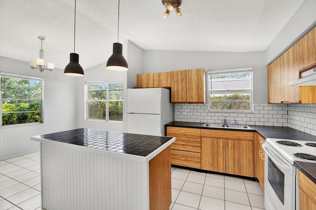 kitchen featuring sink, hanging light fixtures, backsplash, lofted ceiling, and white appliances